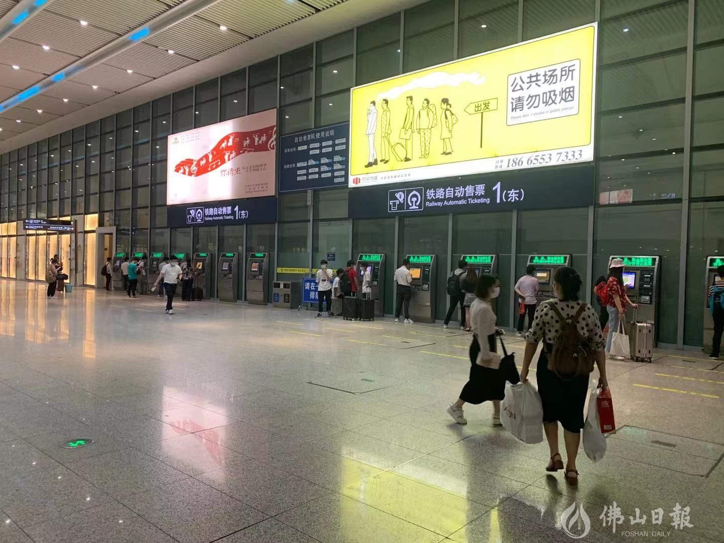 在佛山西站内,部分旅客正在通过进站闸口旁的自助售票机购票进站.