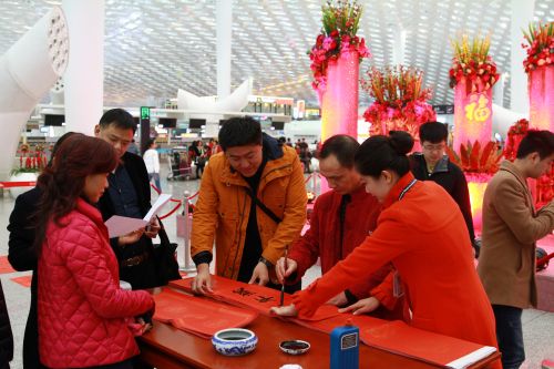 深圳机场航站楼“一派火红”迎春节,书法家现场挥毫送祝福