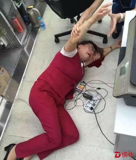 吉祥航空售票柜台处，一名女性工作人员躺在地上表情痛苦，头部枕在手臂上，旁边有明显血迹。