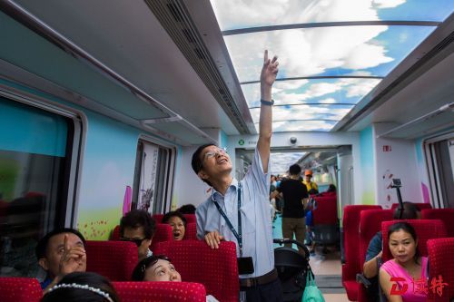 08 地铁11号线商务车厢车顶的蓝天白云图案是试乘市民关注的其中一处亮点，这是地铁工作人员向市民介绍商务车厢特色车顶设计。