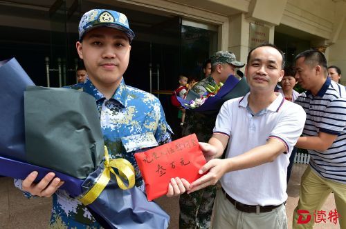 张育彪为入伍青年送上慰问金。
