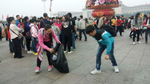 观升旗结束 游客帮环卫工人清理垃圾