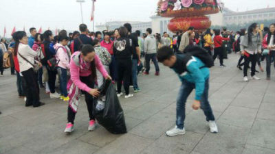 观升旗结束 游客帮环卫工人清理垃圾