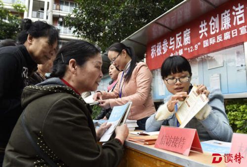 2015年12月8日，在福建省福州市仓山区仓山镇先锋村，纪检监察干部（右）向居民介绍信访举报联系卡使用方法。