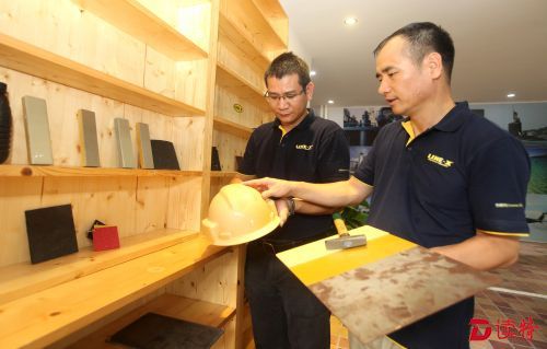 工作人员在介绍测试产品性能。据悉，在头盔上使用能更有效防止尖锐物击穿。