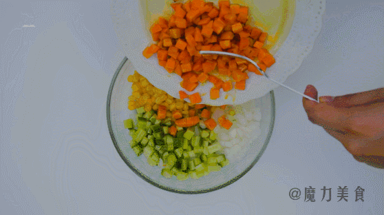 碗中放入洋葱丁、黄瓜丁、玉米粒、和炒好的胡萝卜丁，再放入金枪鱼罐头。