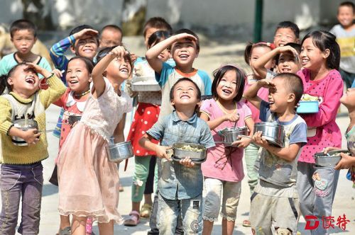 9月23日，在广西大化瑶族自治县板升乡弄雷小学，孩子们在操场上吃营养午餐。我国农村义务教育学生营养改善计划启动实施5年来，广西已有160多万名中小学生告别了曾经的“黄豆拌饭”和“粥瓶午餐”等。新华社记者黄孝邦 摄