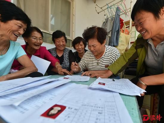 张润棉（右一）在指导村民填写演员信息登记表。