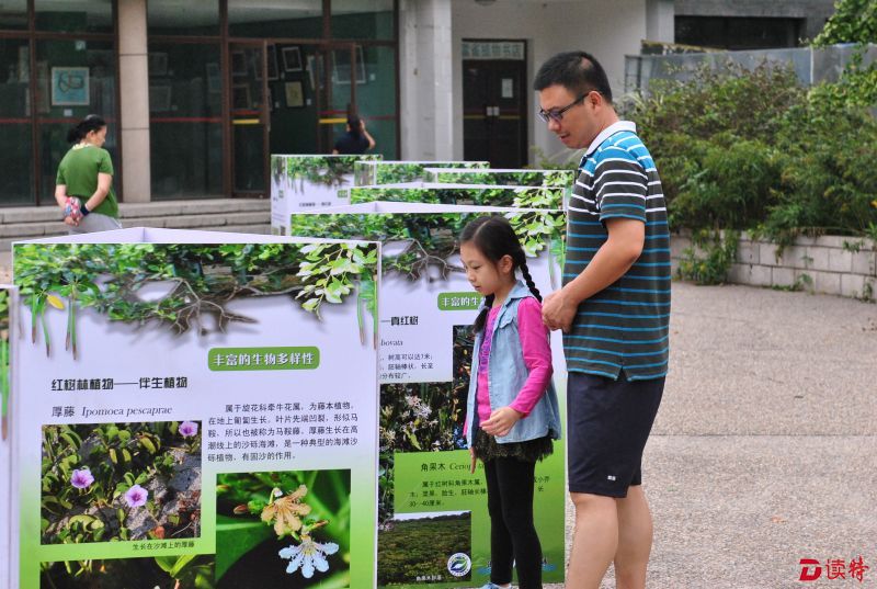 北京活动现场，小游客在家认真听家长解说