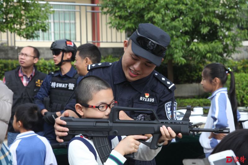 警营开放日中，小学生在警察叔叔的指导下，学习射击。