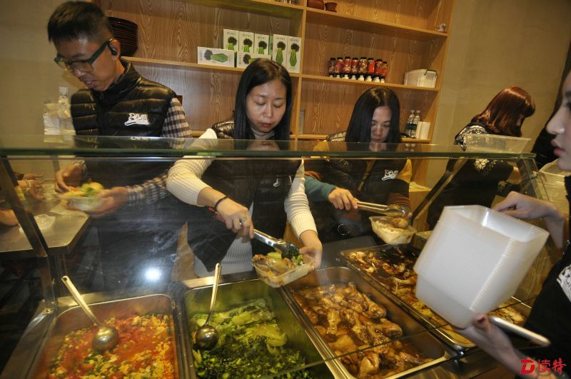 工作人员在打包派发饭盒