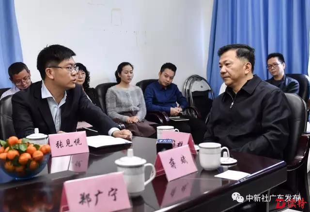 中新社广东分社社长张见悦（图左）向慎海雄介绍过去一年广东分社取得的成绩。