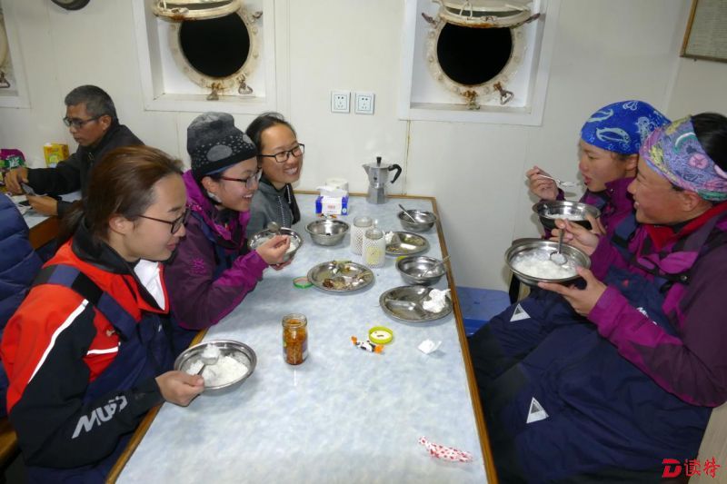 “茉莉花一队”的划手们完成划行任务后在船上吃饭
