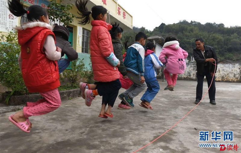 倪华成在广西岑溪市波塘镇杨亦小学为孩子们摇跳绳