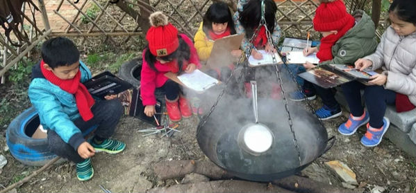 孩子们围坐在森林里，生火、烧水，做着自然笔记。