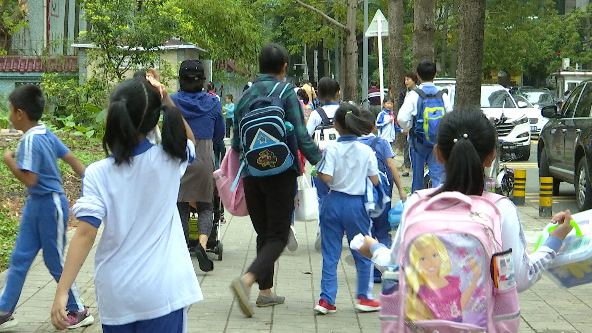 新闻路上说说说丨校长站校门口制止家长替孩子背书包引热议