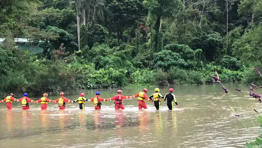 搜救人员牵手在水中搜寻失踪人员