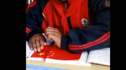 暖心一幕！国旗被雨水淋湿，小学生用校服擦拭国旗上的雨水