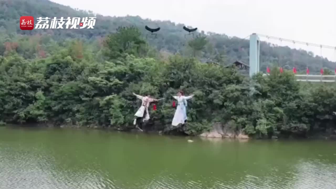 游客景区穿古装吊威亚飞跃水面