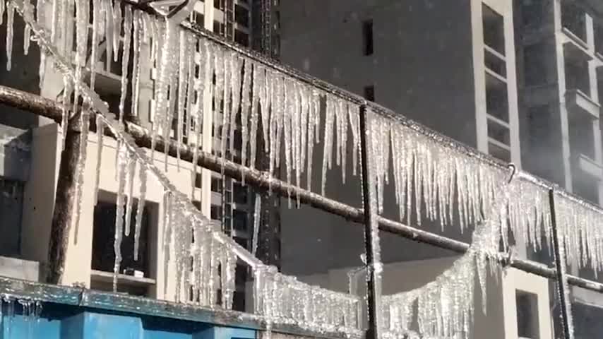 天气降温，郑州一学校门口现百米冰挂路