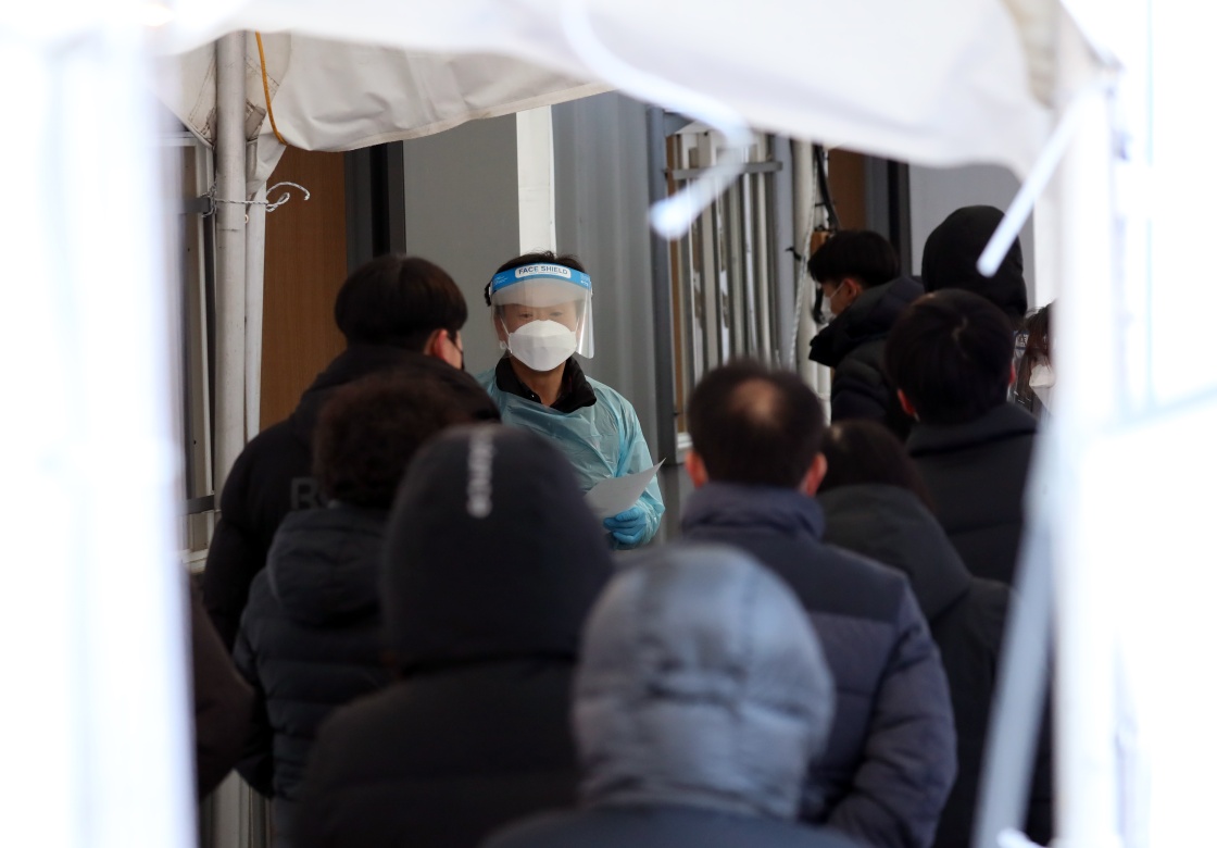 12月14日，一名工作人员在韩国首尔中浪区一处临时筛查所引导市民进行检测。新华社 图