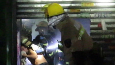 1月4日凌晨新塘一商铺起火，消防员破拆卷帘门成功解救被困男子