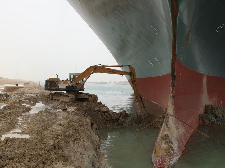 埃及运河搁浅巨轮旁“渺小”挖掘机的工人：面对梗图笑不起来 
