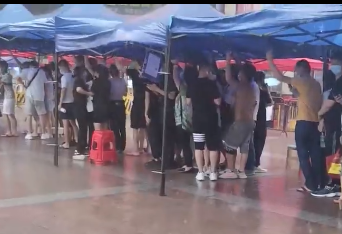 谢谢你们理解！广州市民雨中排队等待核酸检测