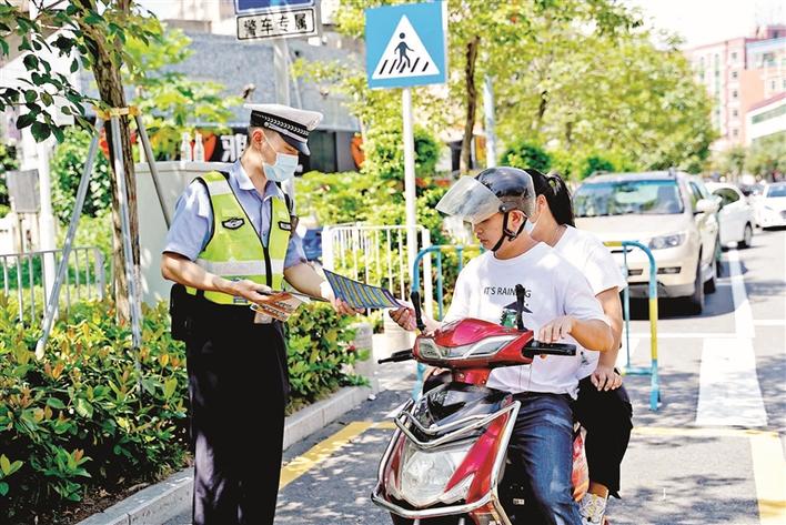 光明交警依法严查骑乘电动车不戴头盔