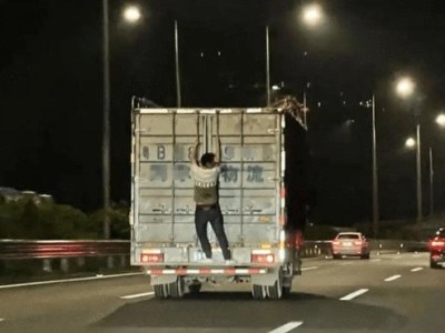惊呆！深圳高速路上一男子扒在疾驰的货车厢门上