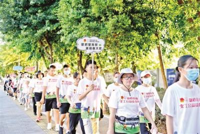 身体力行带动市民践行环保理念 新桥志愿者手持文明标语参与徒步活动 