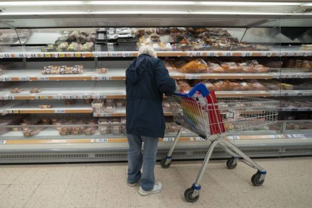 9月22日，一名顾客在英国曼彻斯特一家超市的肉食冷柜货架前选购商品。（新华社发，乔恩·休珀摄）