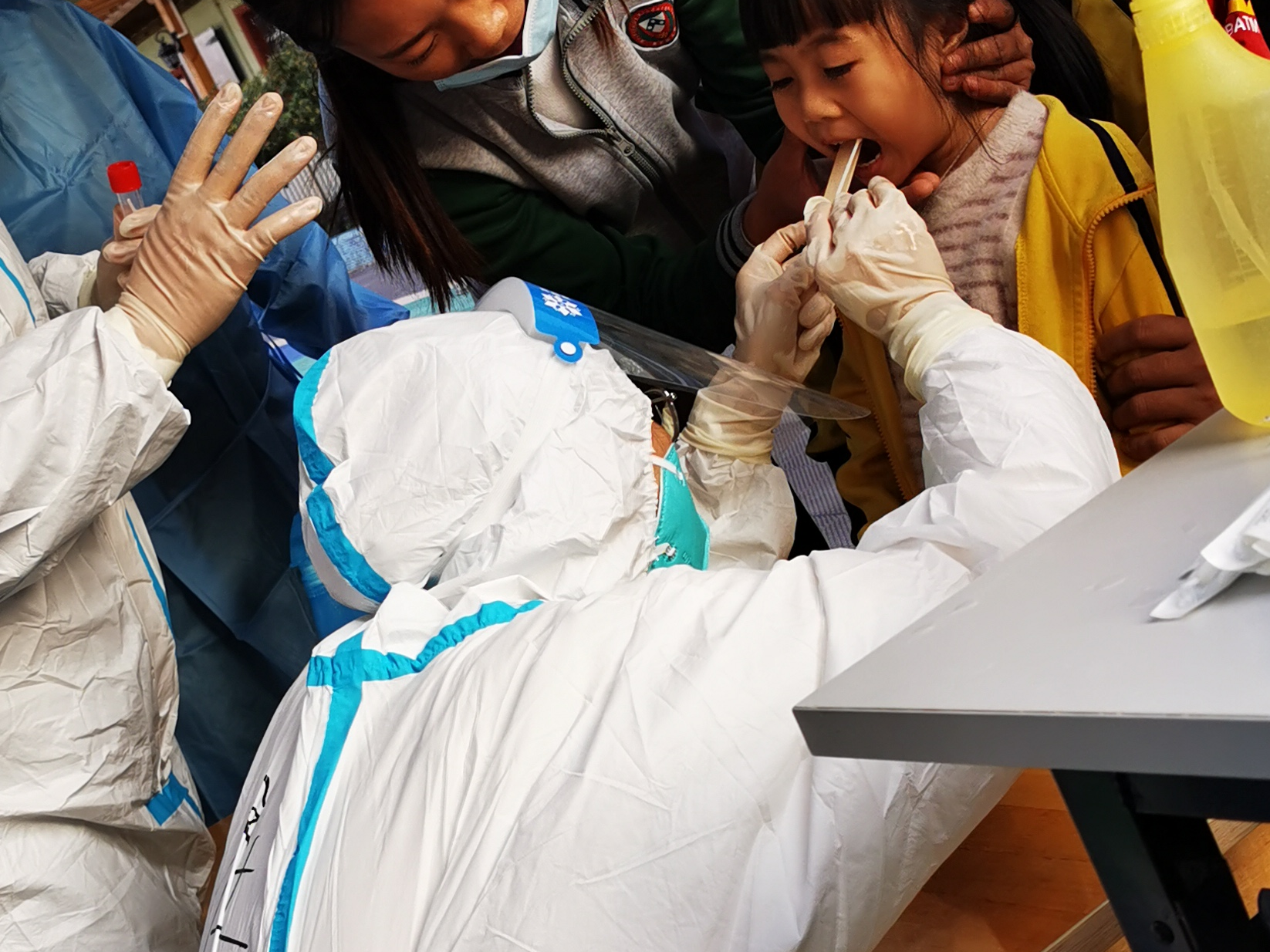 东莞核酸检测现场：俯下身子更显“高”