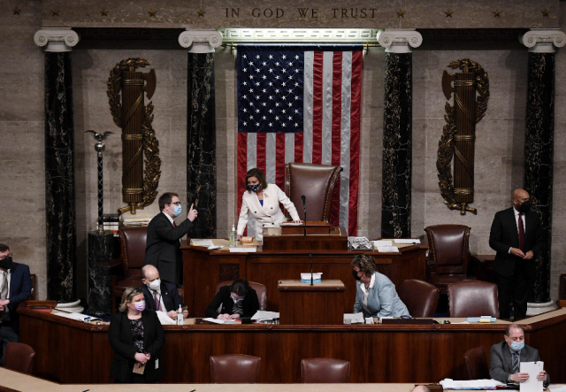 2021年3月10日，众议院议长佩洛西（中）在美国华盛顿的众议院投票现场与人交谈。 新华社/法新 