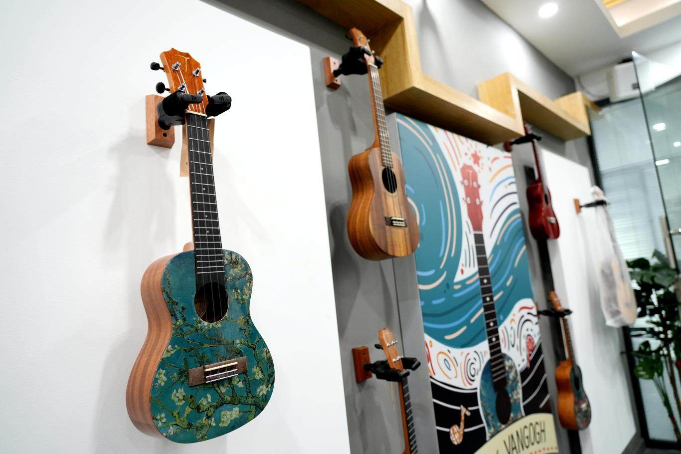 图为惠阳吉他企业行业破圈，制作了梵高画作《盛开的杏花》授权的尤克里里。