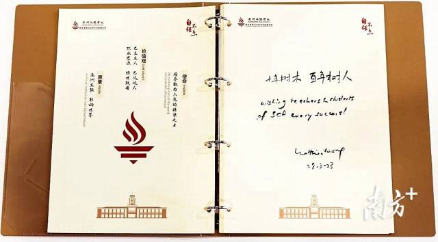 李显龙在广州新侨学校的签名册上题字。 