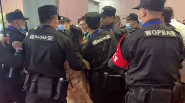 一女子在宝马MINI展位直播时被保安拖走。