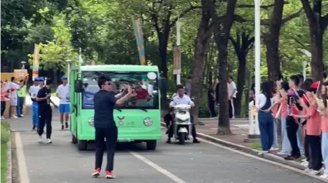深大学子挥旗唱歌 为成都大运会火炬传递助威