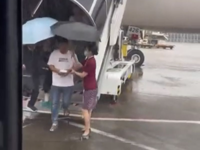 冒雨蹚水撑伞护送旅客下机，南航这位空姐获网友点赞