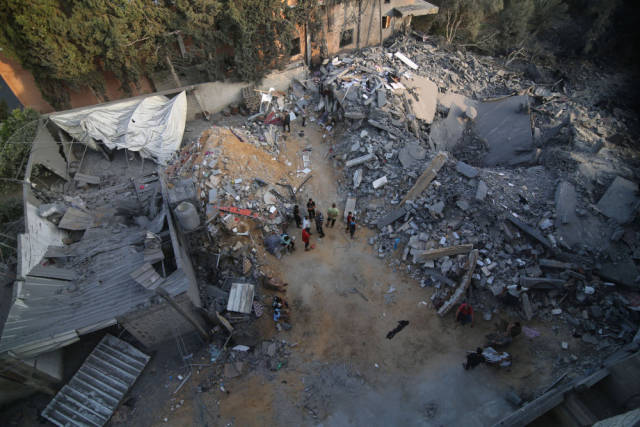 10月14日，在加沙地带南部城市拉法，人们查看遭以色列空袭炸毁的建筑废墟。新华社发（哈立德·奥马尔摄）