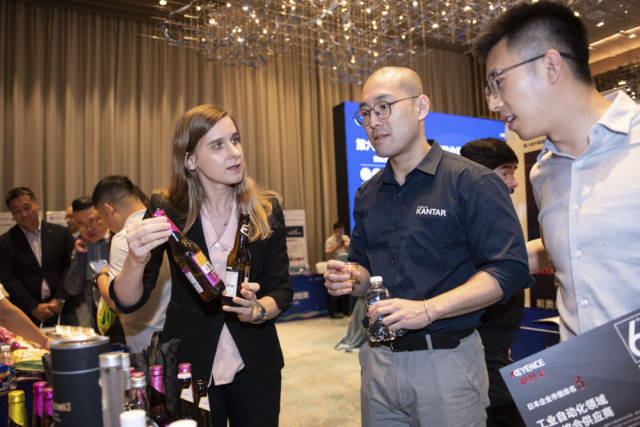 在深圳举行的进博会展前供需对接活动上，波兰投资贸易局的工作人员（左前）向采购商展示风味啤酒（2023年8月29日摄）。新华社记者 毛思倩 摄