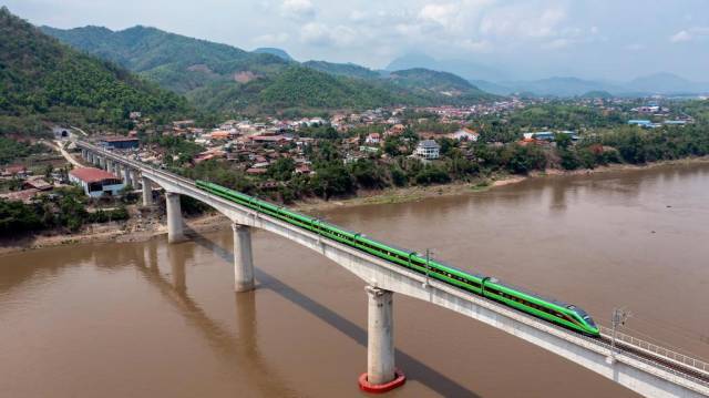 △5月28日，中老铁路客运列车通过老挝琅勃拉邦湄公河特大桥。新华社发