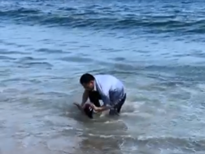 看好孩子！一幼童在大梅沙海边玩沙被海浪拍倒卷走，幸得一游客及时抱起