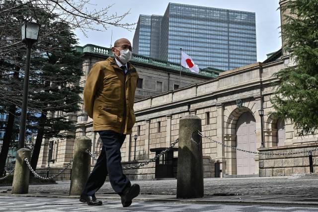 3月19日，在日本东京，行人经过日本央行总部。新华社发