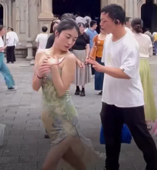 女子在外游玩拍照时，旁边男子疑似故意装瞎欲身体接触。
