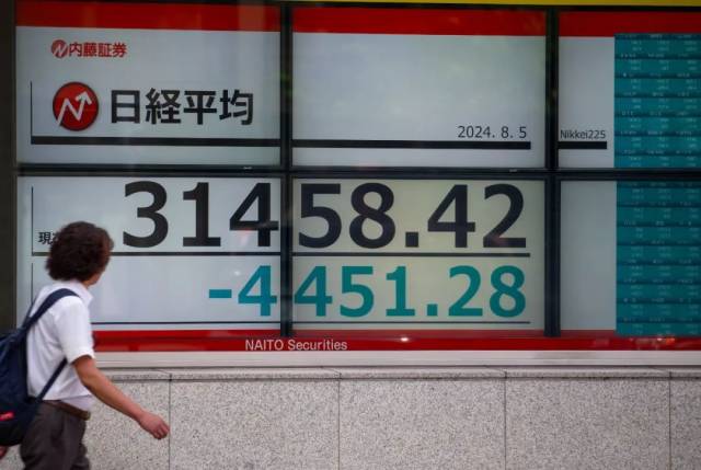 8月5日，行人走过位于日本东京的显示实时股价的电子屏幕。新华社记者 岳晨星 摄