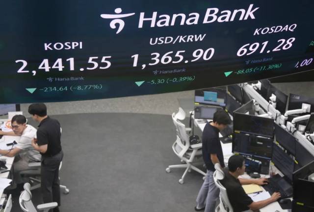 8月5日，工作人员在韩国首尔韩亚银行的股指信息屏幕前工作。新华社记者 姚琪琳 摄