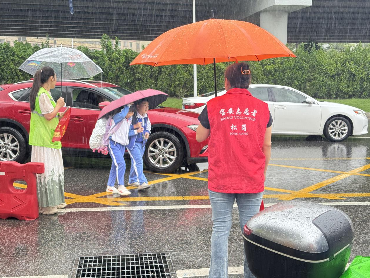 松岗志愿者筑起校园安全防线， 风雨中守护学生平安入学