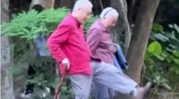 爷爷奶奶手牵手在公园踢脚比高低 网友：此刻幸福具象化