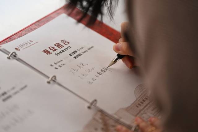 2025年3月27日，参观者在平津战役纪念馆的留言簿上留言“不忘历史 不忘初心”。